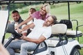 Let`s turn crazy. Family friends having fun riding the golf cart on the field Royalty Free Stock Photo