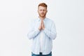 Let there be god. Portrait of calm serious-looking mature redhead european man in shirt, holding hands in pray near Royalty Free Stock Photo