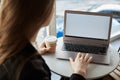 Let uf check last news. Indoor rearview of stylish woman sitting in cafe, drinking cup of coffee and working with laptop