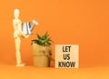 Let us know symbol. Concept words Let us know on wooden blocks on a beautiful orange table orange background. Businessman model.