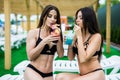 Let the vacation begin. Two beautiful women having cocktails together by the swimming pool Royalty Free Stock Photo