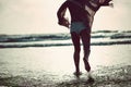 Let the water kiss your feet. Rearview shot of an unrecognizable woman spending a day at the beach.