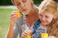 Let your inner child out. Shot of a young mother blowing bubbles with her daughter. Royalty Free Stock Photo