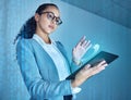 Lets bring this closer. an attractive young businesswoman standing alone in the office and using a digital tablet.