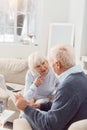 Elderly beaming couple on the sofa in a room