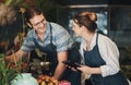 Lets do a quick stocktake of our flowers and plants. two young florists working together inside their plant nursery. Royalty Free Stock Photo