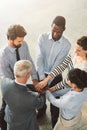 Lets do this team. High angle shot of a group of businesspeople standing in a huddle together in an office lobby. Royalty Free Stock Photo