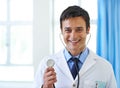 Lets find out whats in there. Portrait of a handsome young doctor smiling and holding a stethoscope. Royalty Free Stock Photo