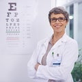 Lets find the perfect pair of glasses for you. Portrait of a female optometrist standing beside an eye test poster.