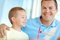 Lets fly it, dad. Young boy looking at his dad holding a model airplane. Royalty Free Stock Photo