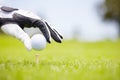 Lets get this ball rolling. Cropped image of a golfer placing the ball ready to tee off on a golf course. Royalty Free Stock Photo