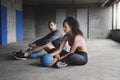 Lets get the ball rolling. Full length shot of sporty young couple sitting down and exercising with a ball inside a Royalty Free Stock Photo