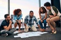 Lets get down and busy. a group of focussed young coworkers working together and brainstorming while being seated on the Royalty Free Stock Photo