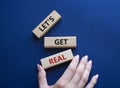 Lets get real symbol. Concept words Lets get real on wooden blocks. Beautiful deep blue background. Businessman hand. Business and Royalty Free Stock Photo