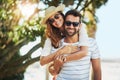 Lets get this summer started. Cropped portrait of a handsome young man giving his girlfriend a piggyback ride at the Royalty Free Stock Photo