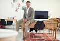 Lets get to work. Portrait of a casually-dressed young man sitting on his desk in an office. Royalty Free Stock Photo