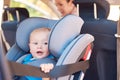 Lets go, Mom. a mother sitting in a car with her baby boy in a car seat. Royalty Free Stock Photo