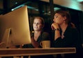 Lets go over it one last time before shutting down. two businesswoman looking at something on a computer in an office at Royalty Free Stock Photo