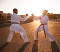 Lets go...Two sportspeople facing off and practicing their karate while wearing gi.
