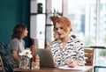 Lets have a look at my inbox. an attractive middle aged woman working on her laptop while making notes inside of a Royalty Free Stock Photo