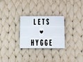 LETS HYGGE word on lightbox on knit background. Cozy compozition. Knit background. Royalty Free Stock Photo