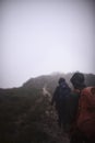 Lets just go wherever the trail takes us. two male friends out hiking in the mountains on a foggy day.