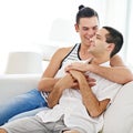 Lets just stay here all day. a young gay couple relaxing on a sofa at home. Royalty Free Stock Photo