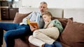 Lets read a story. Grandfather reading a book with his little grandson while relaxing on sofa at home Royalty Free Stock Photo