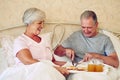 Lets share the most important meal of the day. a senior couple having breakfast in bed together.