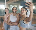 Lets show them just how much fun the gym is. three young athletes taking a selfie while standing together in the gym.