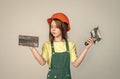 lets start. renovation and repair. using working tool. teen girl in helmet and boilersuit with spatula. child wear hard