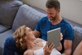 Lets stay in and stream movies all day. a happy middle aged couple using a digital tablet together on the sofa at home. Royalty Free Stock Photo