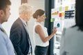 Lets take a look at our stats over here. a woman giving a presentation to colleagues in an office. Royalty Free Stock Photo