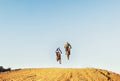 Lets take the race to the sky. Two motocross riders clearing a jump during a race. Royalty Free Stock Photo