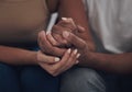 Lets use the strength of our love to overcome this. an unrecognizable couple sitting inside together and holding hands.