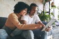 Lets watch this one next. a young couple using a digital tablet together at home.