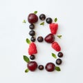 Flat lay pattern of letter B english alphabet from natural ripe berries - black currant, cherries, raspberry, mint leaf Royalty Free Stock Photo