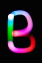 Letter B. Glowing letters on dark background. Abstract light painting at night. Creative artistic colorful bokeh. New Year.
