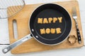 Letter biscuits word HAPPY HOUR and cooking equipments.