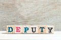 Letter block in word deputy on wood background