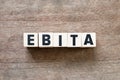 Letter in word EBITA abbreviation of earnings before interest, taxes and amortizationon wood background