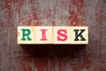Letter block in word risk on red wood background Royalty Free Stock Photo
