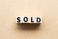 Letter block in word sold on wood background Royalty Free Stock Photo
