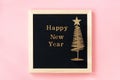 Letter board with golden text Happy New year and shiny christmas tree on pink background. New year greeting card Royalty Free Stock Photo