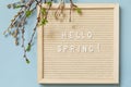 Letter Board with quote HELLO SPRING and with green branches on a blue background, minimalism style composition. Springtime Royalty Free Stock Photo
