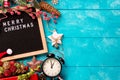 Letter board with words Merry Christmas, vintage clock and decorations on blue wooden table. Winter Christmas celebration concept