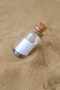 Letter in a bottle on the beach. Island lifestyle. Paper Message in a glass bottle with a cork on the sand. Note on Royalty Free Stock Photo