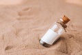 Letter in a bottle on the beach. Island lifestyle. Paper Message in a glass bottle with a cork on the sand. Note on Royalty Free Stock Photo