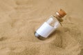 Letter in a bottle on the beach. Island lifestyle. Paper Message in a glass bottle with a cork on the sand. Note on Royalty Free Stock Photo