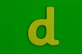 Letter d made of wood painted yellow on green background